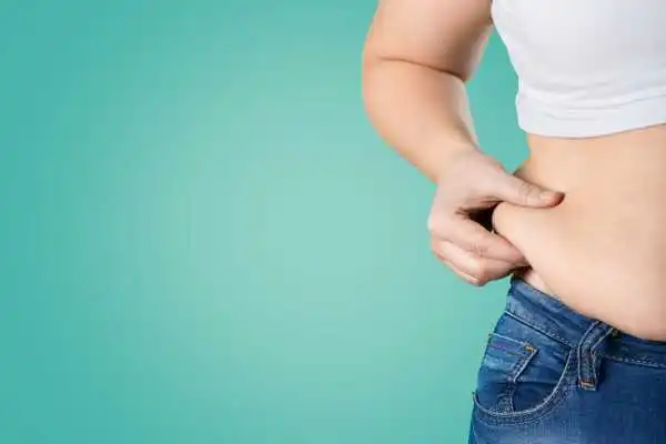 Image of woman pinching her love handles to show weight gain Stowmarket